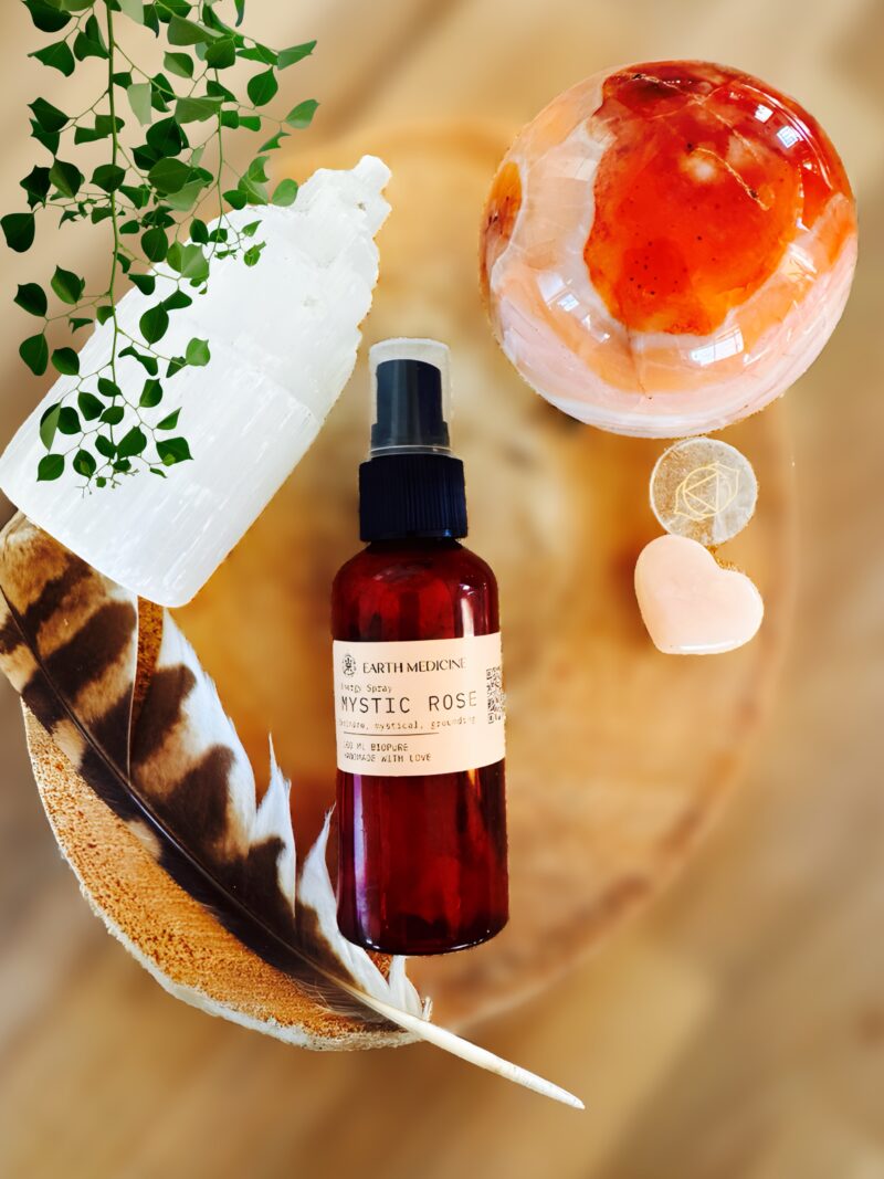 Flesje Mystic Rose Energy Spray op plateau met veer en kristallen