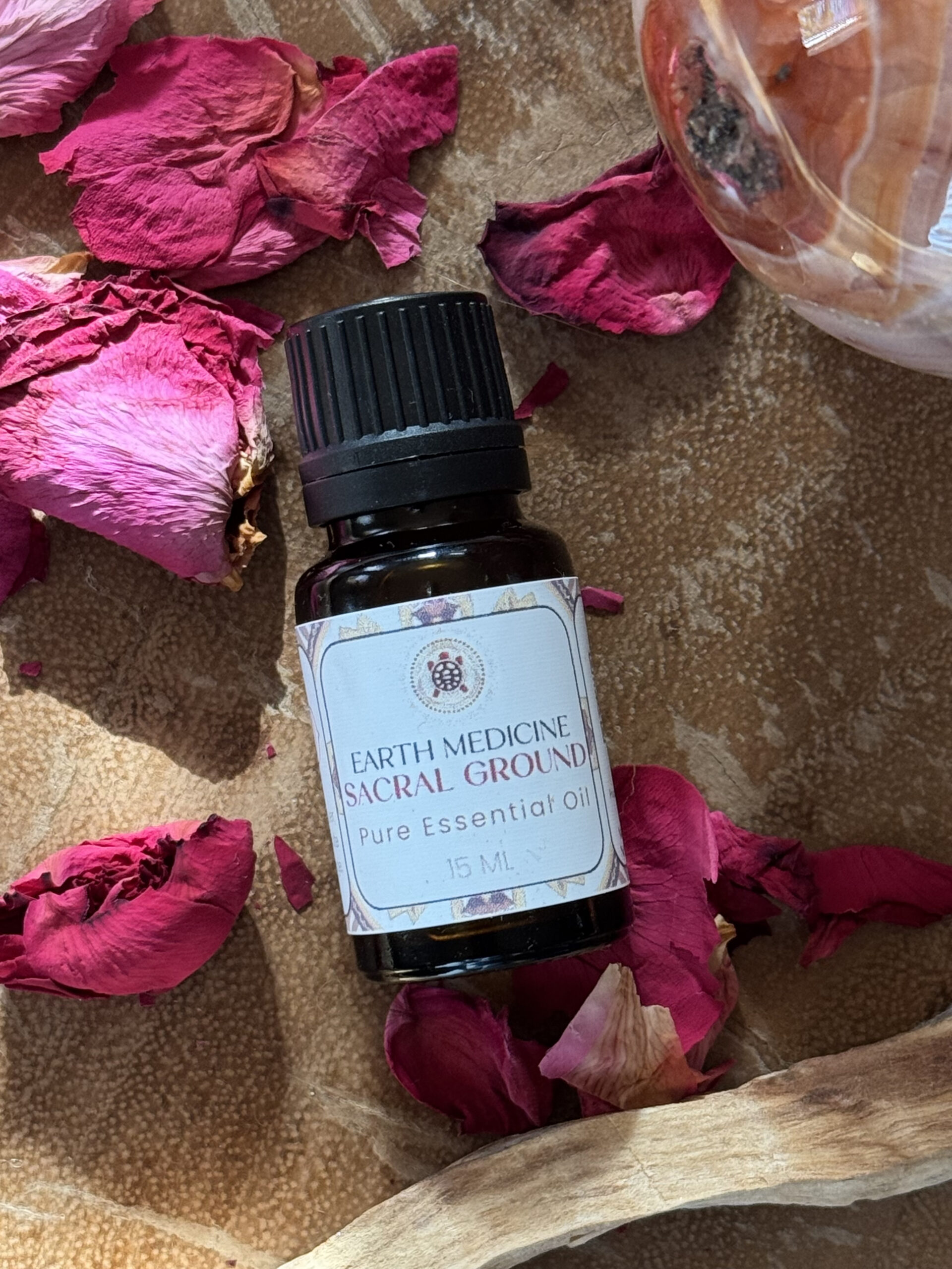 Flesje Sacral Ground essentiële olieblend met warme aardse kleuren, gecreëerd voor gronding, stroming en sensuele aanwezigheid.